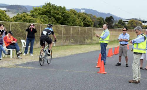 A participant crosses the line to finish the inaugural BCU Coffs Coast Cycle Challenge, watched by race officials. A participant crosses the line to finish the inaugural BCU Coffs Coast Cycle Challenge, watched by race officials.